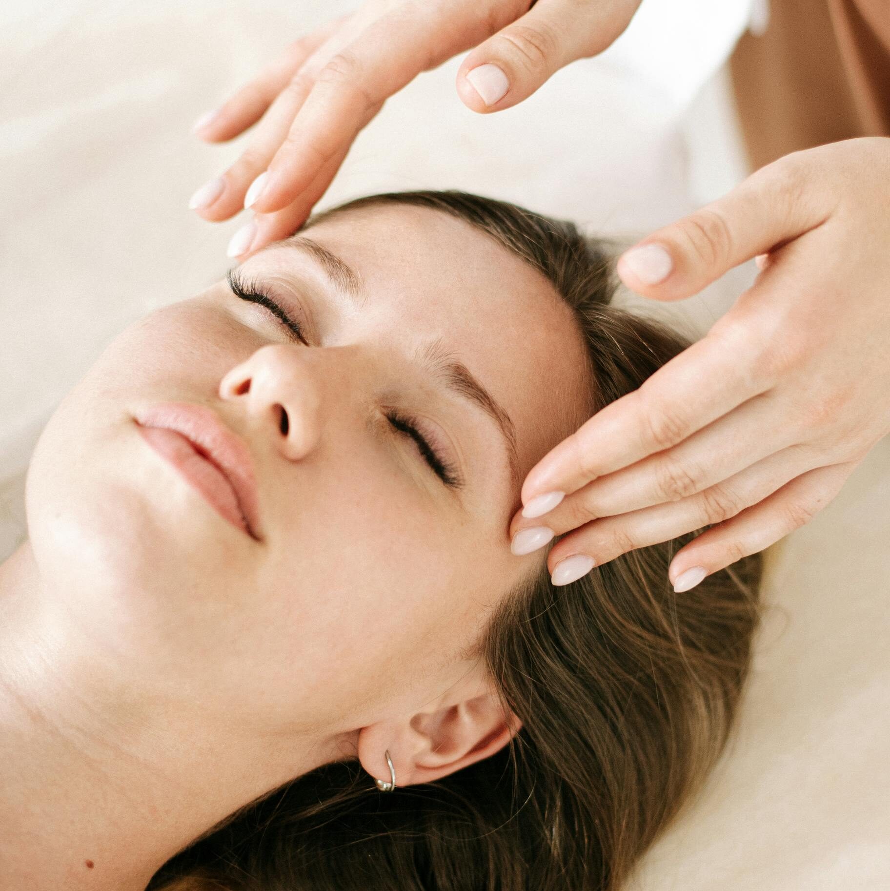 Woman receiving a soothing facial massage in a relaxing spa environment.